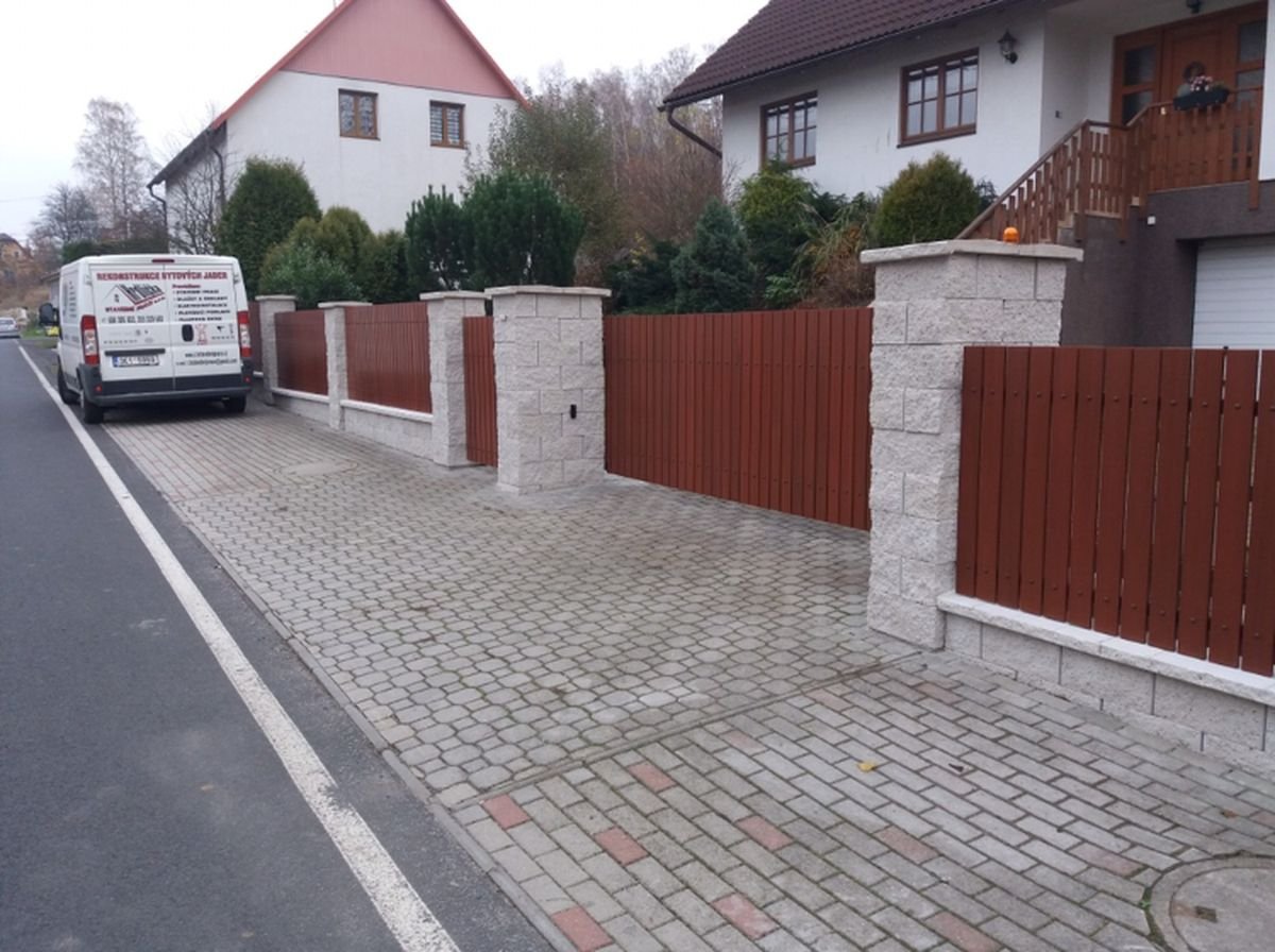 Oplocení s kamennými sloupky a dřevěnou výplní, zámková dlažba u silnice – realizace