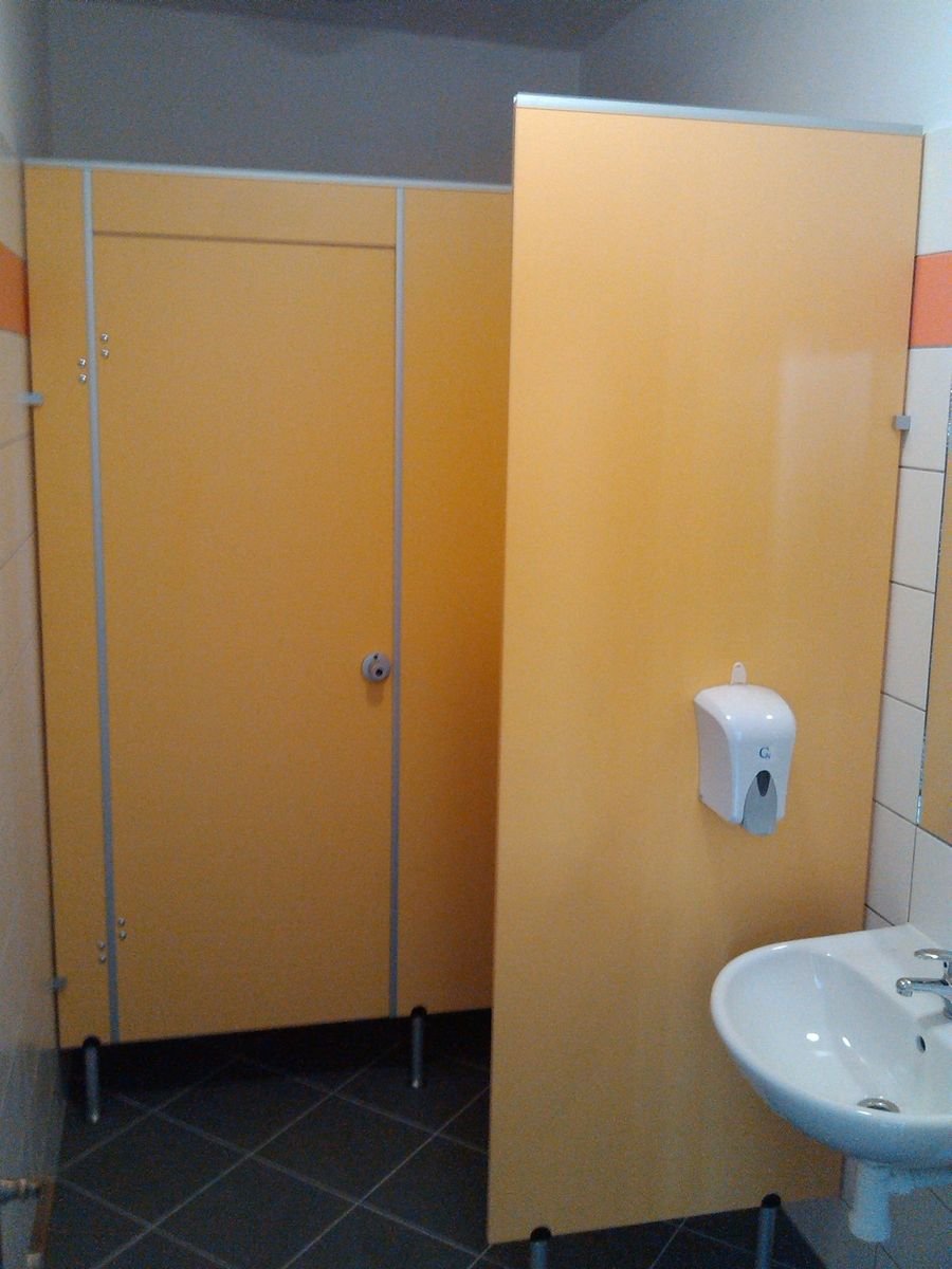Sanitární příčky s dveřmi a umyvadlo na obložených stěnách – realizace
