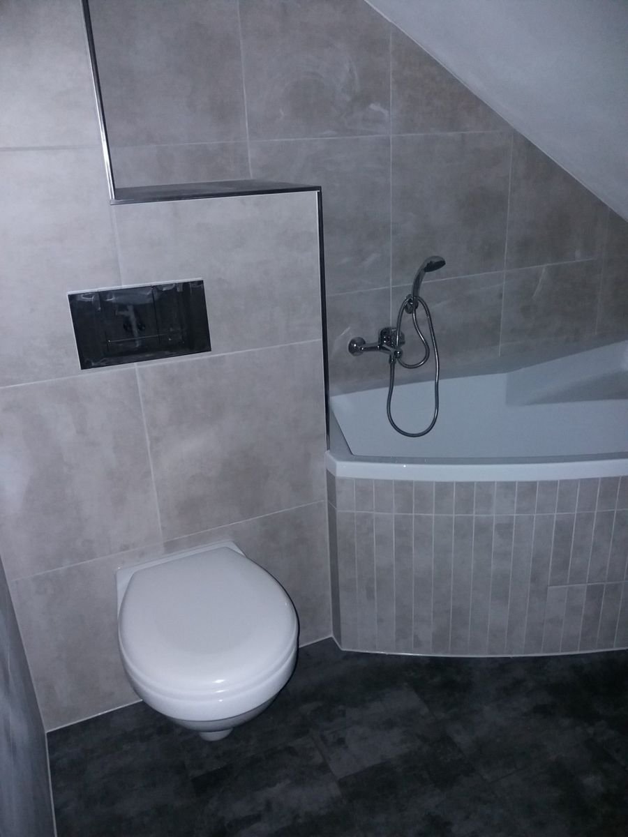 Koupelna se šikmým stropem, vanou a závěsným WC – realizace