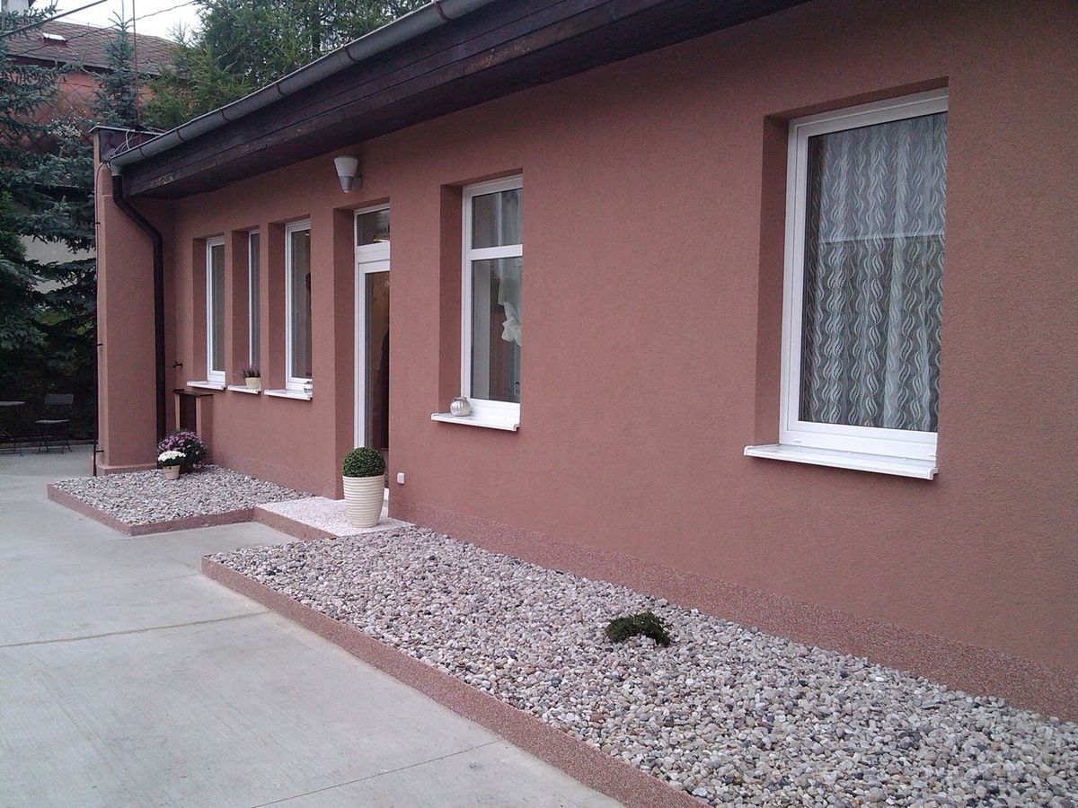 Plastová okna s bílými parapety na dokončené fasádě – realizace
